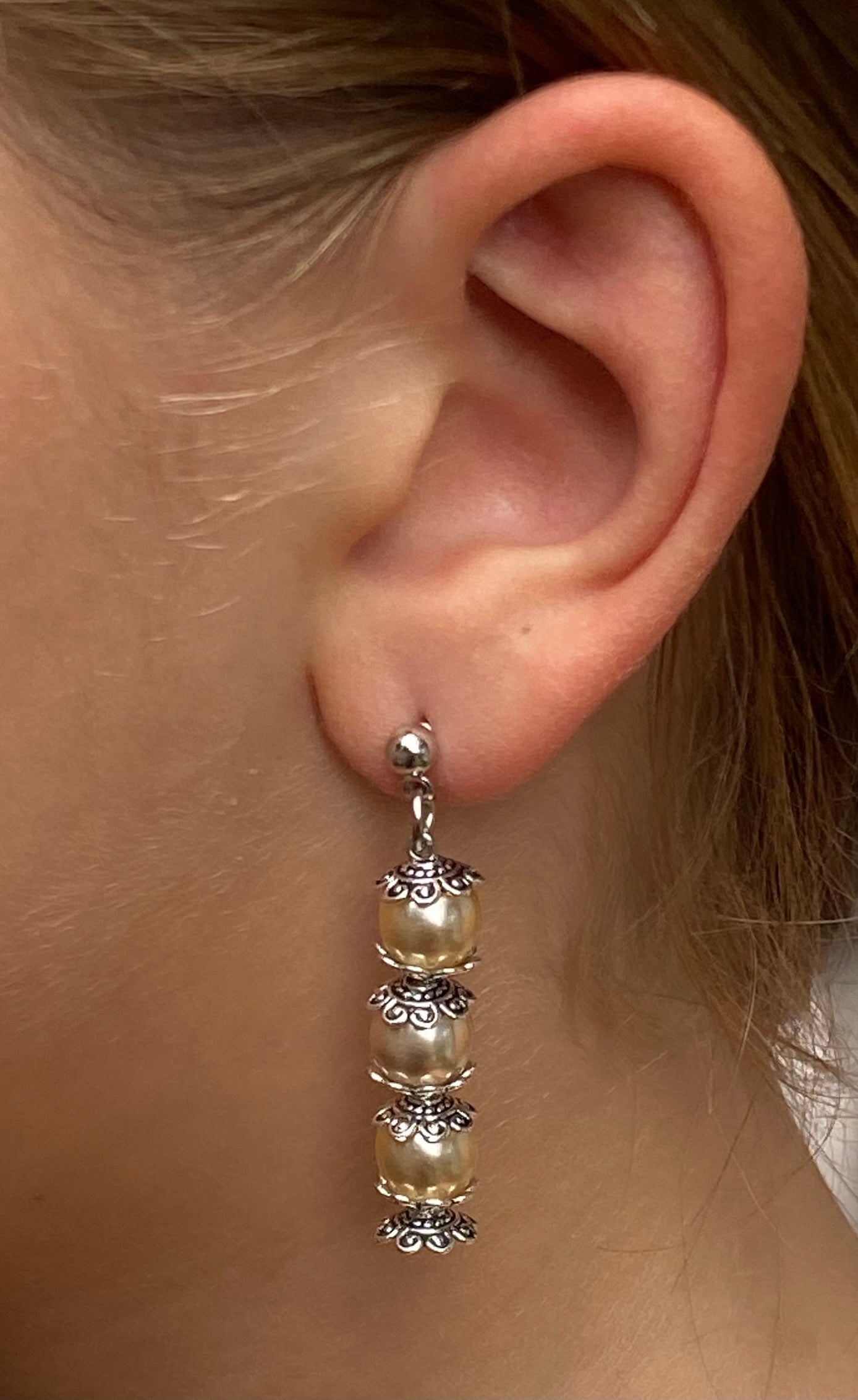 Pendientes largos con tres perlas en color crudo y filigrana plateada envejecida